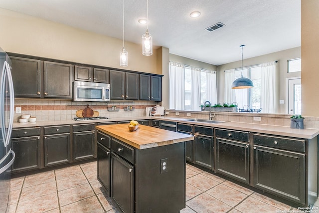 823 Peg Oak, San Antonio, TX 78258 - kitchen with stainless steel appliances, butcher block countertops, a sink, a peninsula, and a kitchen island
