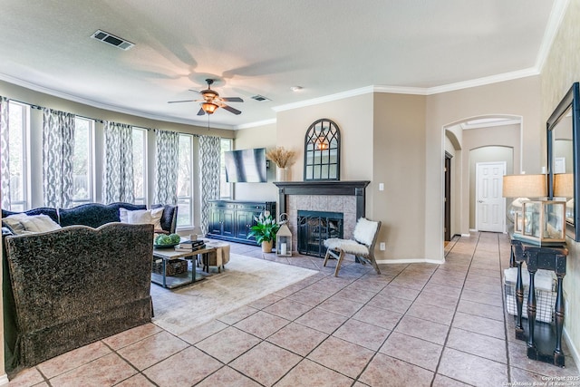 823 Peg Oak, San Antonio, TX 78258 - living room featuring a ceiling fan, arched walkways, a fireplace, crown molding, and light tile patterned floors