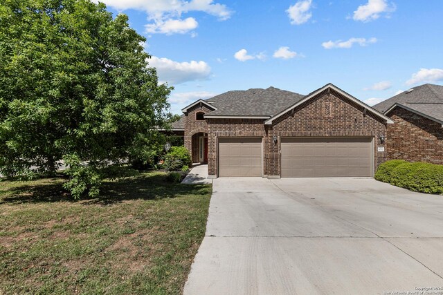 1002 Faith Rnch, San Antonio, TX 78245 - view of front of property featuring brick siding, an attached garage, concrete driveway, a shingled roof, and a front lawn