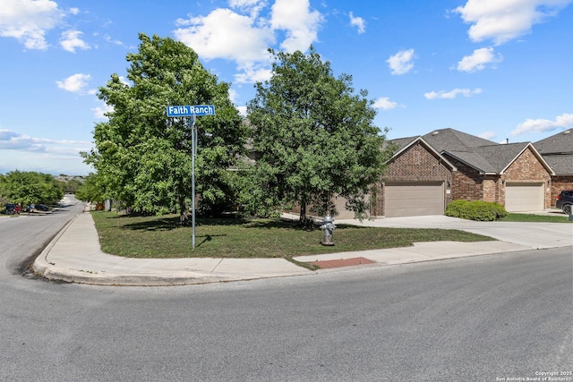 1002 Faith Rnch, San Antonio, TX 78245 - view of front facade with brick siding, concrete driveway, a garage, and a front lawn