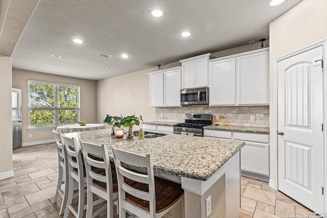 1002 Faith Rnch, San Antonio, TX 78245 - kitchen featuring stainless steel appliances, recessed lighting, backsplash, a sink, and an island with sink
