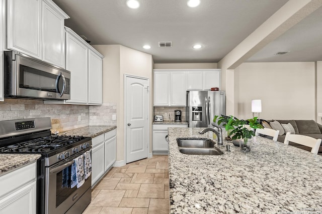 1002 Faith Rnch, San Antonio, TX 78245 - kitchen featuring appliances with stainless steel finishes, a sink, white cabinetry, and recessed lighting