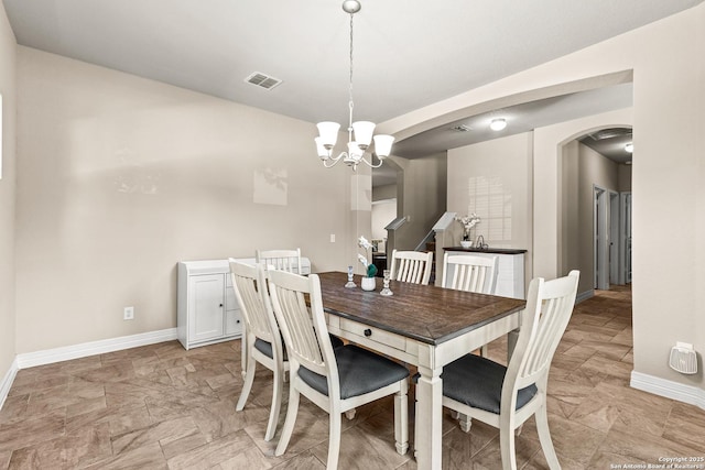 1002 Faith Rnch, San Antonio, TX 78245 - dining room featuring arched walkways, a chandelier, baseboards, and light stone finish floors