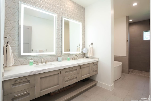 full bathroom with a freestanding tub, double vanity, tasteful backsplash, recessed lighting, and baseboards