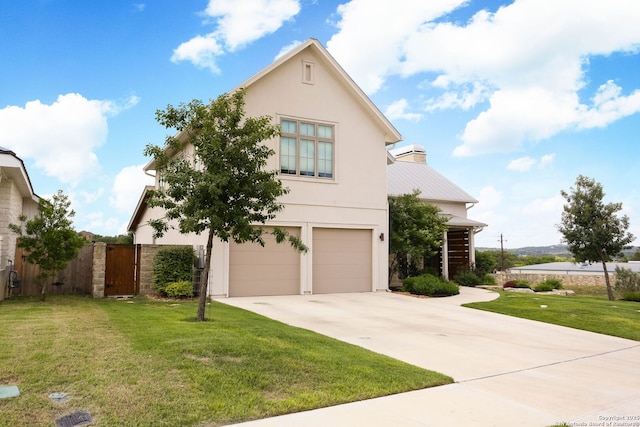 view of front of property featuring concrete driveway, an attached garage, stucco siding, a gate, and a chimney