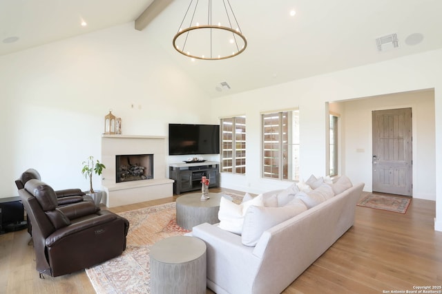 living room with beamed ceiling, a chandelier, wood finished floors, high vaulted ceiling, and recessed lighting