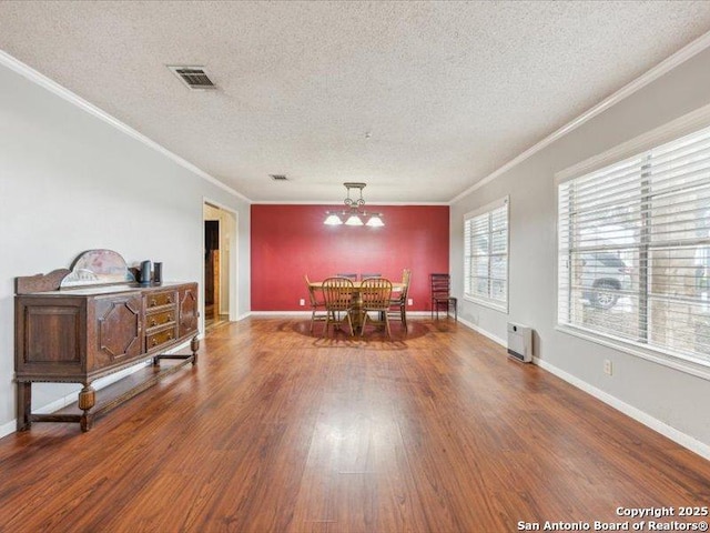 1010 Country Oak Dr, Luling, TX 78648 - dining area with crown molding, a chandelier, wood finished floors, a textured ceiling, and baseboards