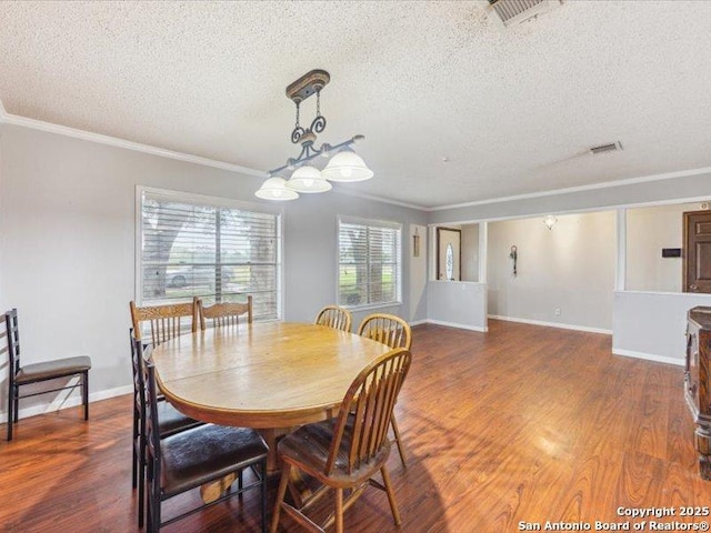 1010 Country Oak Dr, Luling, TX 78648 - dining space with a textured ceiling, crown molding, wood finished floors, and baseboards