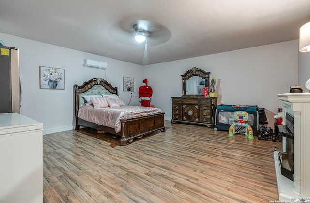 6136 Sunflower, San Antonio, TX 78244 - bedroom featuring light wood-style floors, an AC wall unit, freestanding refrigerator, and a fireplace with raised hearth