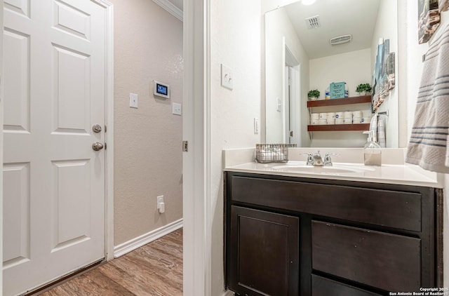 6136 Sunflower, San Antonio, TX 78244 - bathroom featuring wood finished floors, a textured wall, baseboards, and vanity