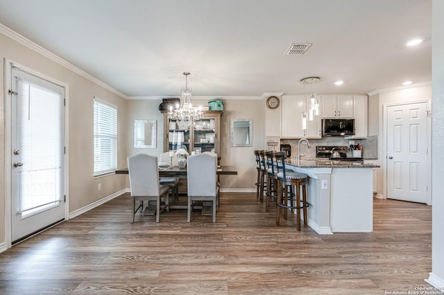 6136 Sunflower, San Antonio, TX 78244 - dining area featuring a chandelier, plenty of natural light, light wood-style flooring, crown molding, and baseboards