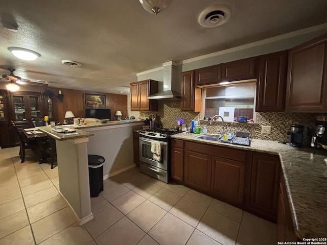 3802 Quiver, San Antonio, TX 78238 - kitchen featuring wall chimney range hood, stainless steel gas range, a peninsula, and backsplash