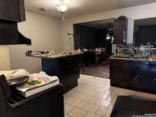 5039 Bayhead, San Antonio, TX 78220 - kitchen with a sink, ceiling fan, backsplash, stone countertops, and light tile patterned flooring