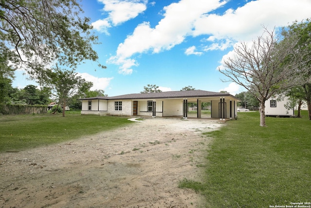 8160E 6th St, Somerset, TX 78069 - rear view of property featuring dirt driveway, a yard, a carport, and stone siding