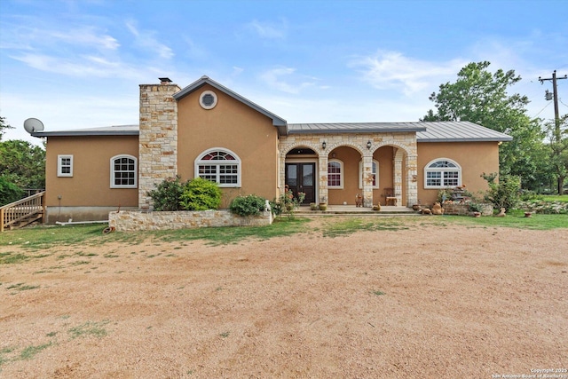 3205 Puter Crk, Spring Branch, TX 78070 - view of front of home with a standing seam roof, stucco siding, a chimney, and covered porch