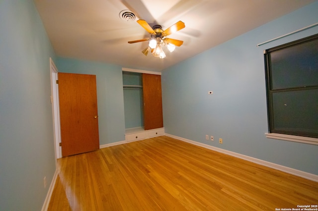unfurnished bedroom with light wood-style flooring, baseboards, a closet, and ceiling fan