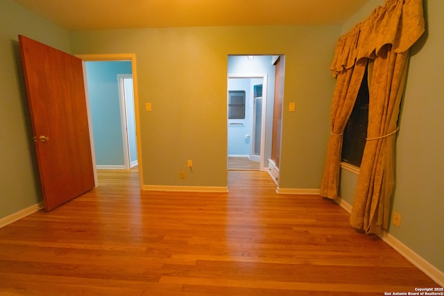 corridor with light wood-style floors and baseboards