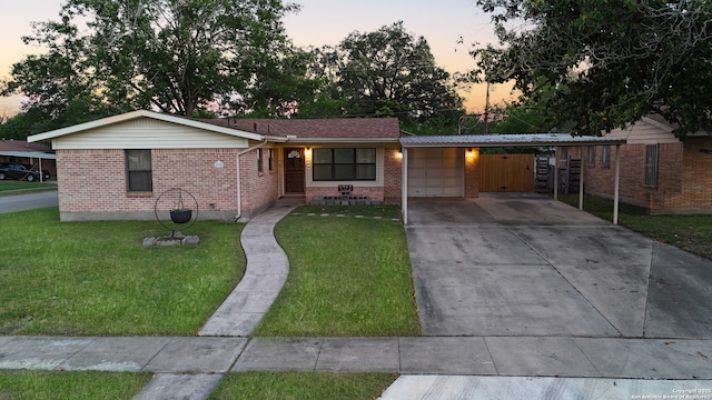 ranch-style house featuring brick siding, a front yard, an attached garage, and concrete driveway