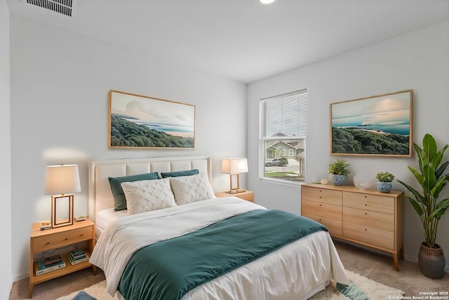 bedroom with light colored carpet and baseboards