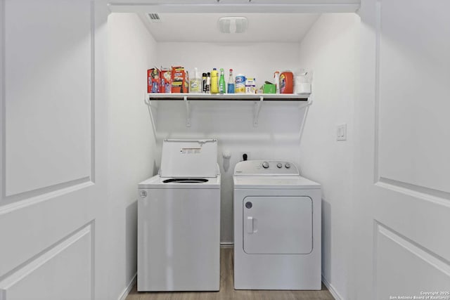 laundry area featuring separate washer and dryer and light wood-style floors