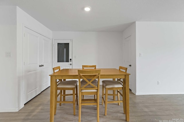 dining room featuring light wood-style flooring, baseboards, and recessed lighting
