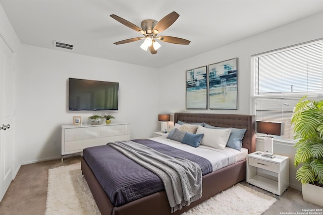 bedroom featuring light carpet, a ceiling fan, and baseboards