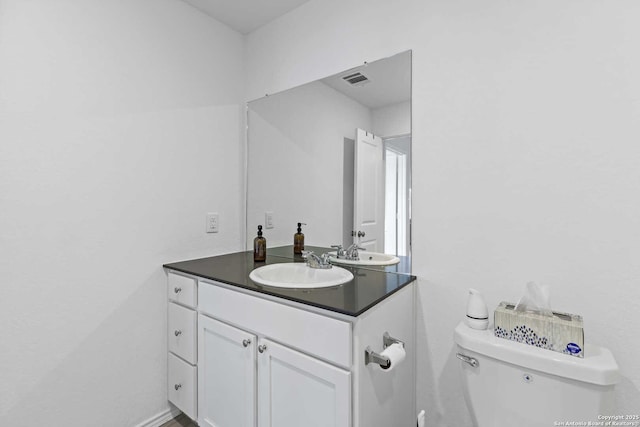 half bathroom featuring vanity and toilet