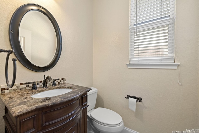 half bath featuring vanity and toilet