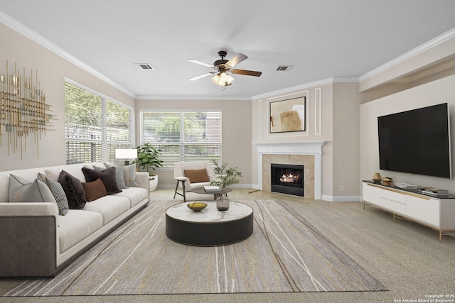 living room with ornamental molding, ceiling fan, a tiled fireplace, and baseboards