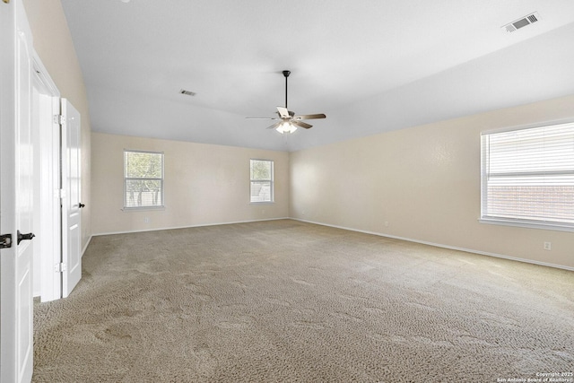 empty room featuring a ceiling fan, carpet floors, baseboards, and lofted ceiling