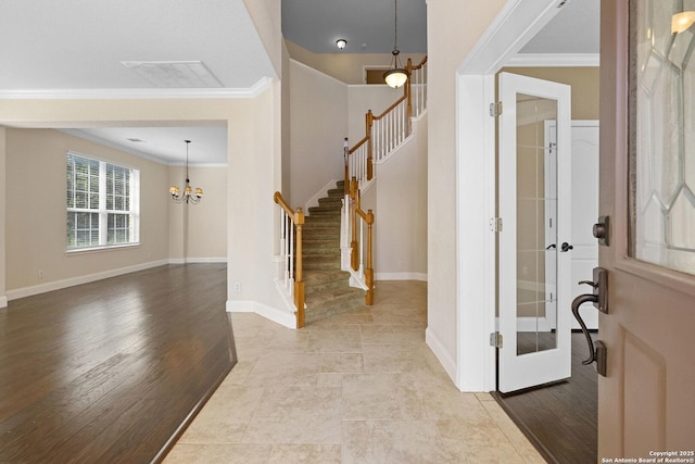 foyer with crown molding, stairway, a chandelier, and baseboards