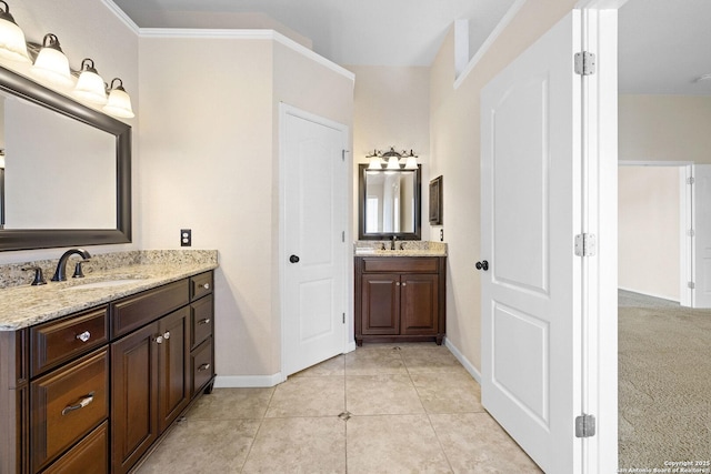 bathroom with baseboards, two vanities, and tile patterned floors