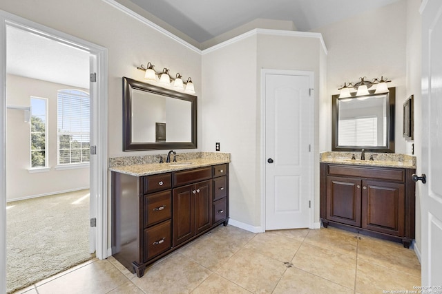 bathroom featuring two vanities, tile patterned floors, ornamental molding, and baseboards