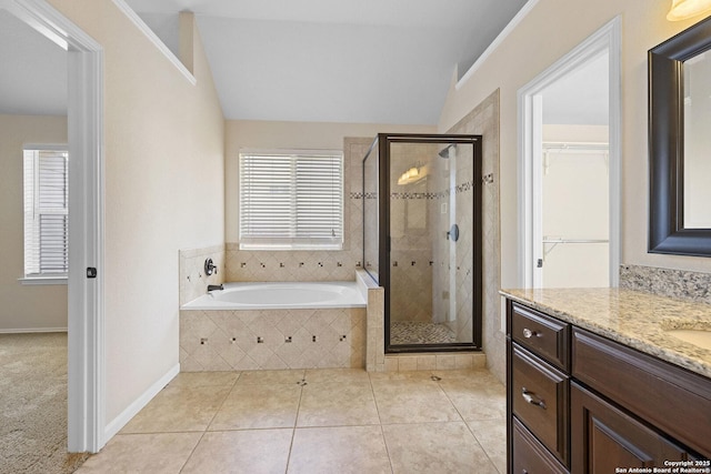 bathroom featuring a shower stall, vanity, a garden tub, tile patterned floors, and a spacious closet