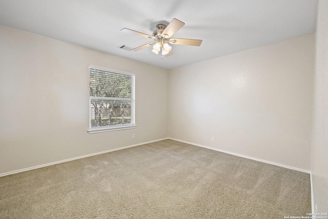 carpeted empty room featuring baseboards and a ceiling fan
