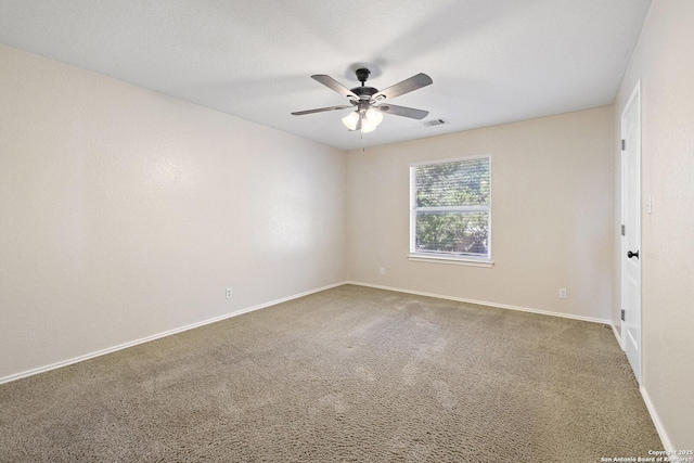 carpeted empty room with a ceiling fan and baseboards