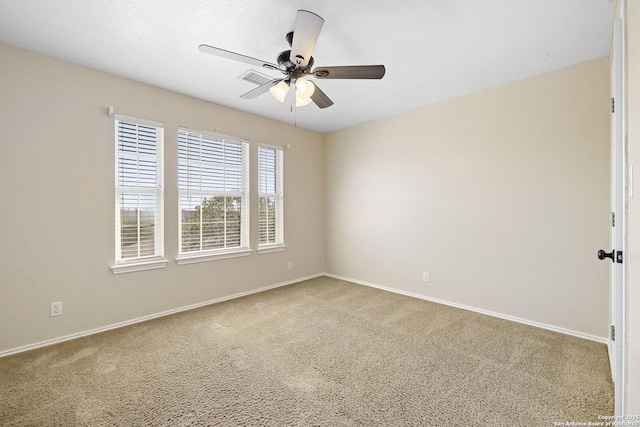 carpeted empty room with a ceiling fan and baseboards