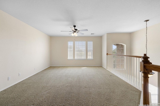 unfurnished room with a ceiling fan, carpet floors, and baseboards