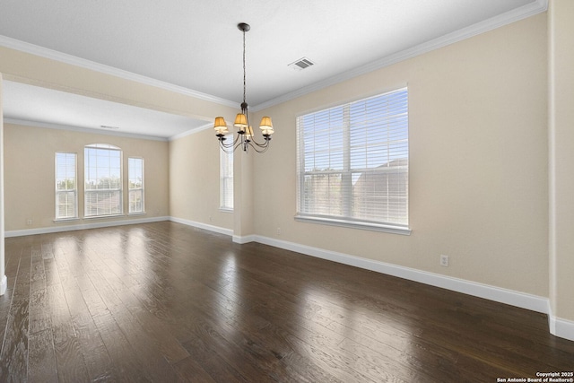 spare room featuring a chandelier, dark wood finished floors, baseboards, and crown molding