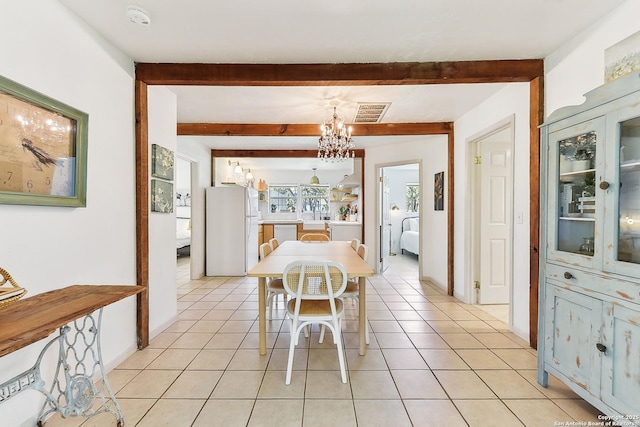 dining area with a chandelier, beamed ceiling, and light tile patterned floors