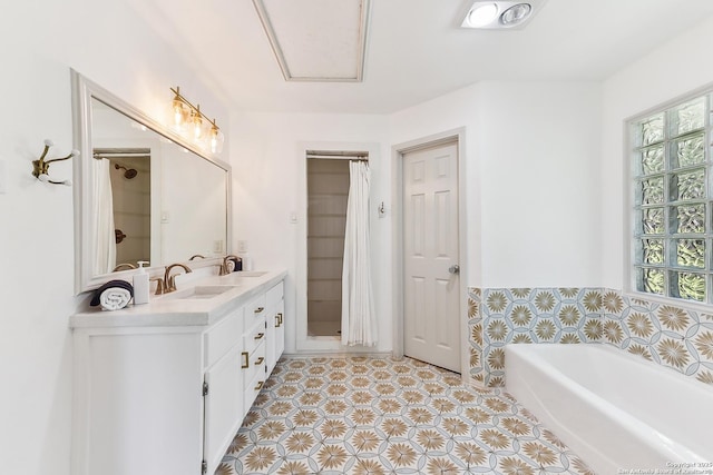 bathroom with a bath, plenty of natural light, double vanity, and tile patterned floors