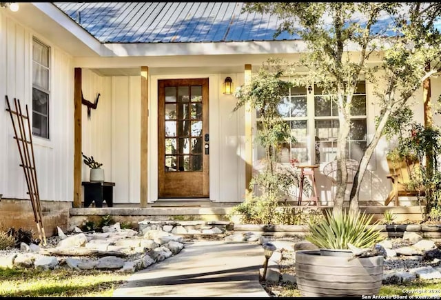 view of exterior entry with covered porch and metal roof
