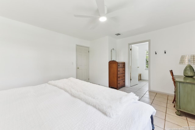 bedroom featuring light tile patterned floors, a ceiling fan, and connected bathroom