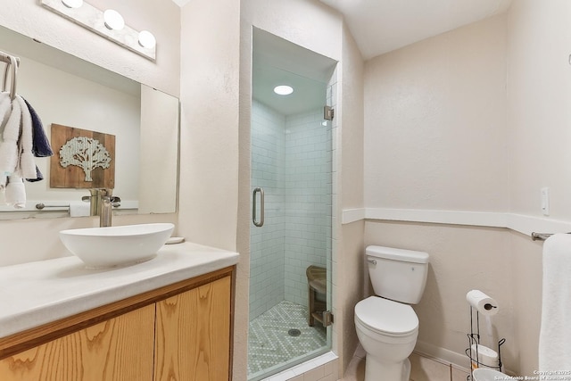 bathroom featuring toilet, a shower stall, vanity, and tile patterned floors