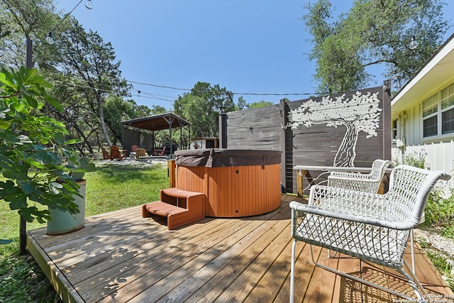 wooden terrace featuring a hot tub and fence