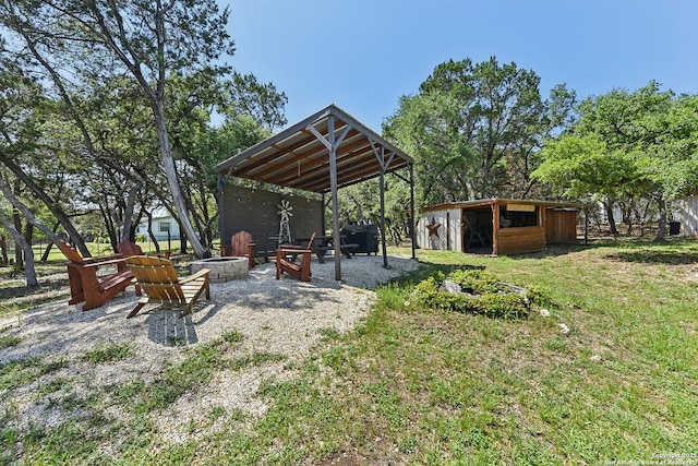 view of patio / terrace with a fire pit and an outbuilding