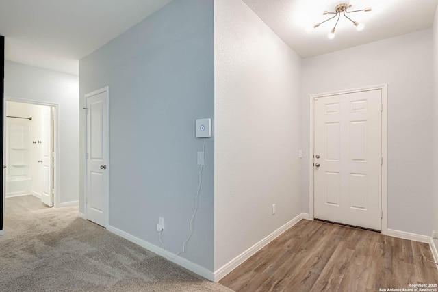 hall with baseboards and wood finished floors