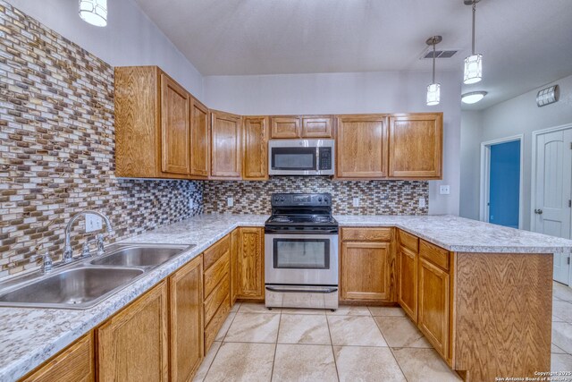 120 W Brazos, Uvalde, TX 78801 - kitchen with stainless steel appliances, a sink, a peninsula, tasteful backsplash, and light countertops