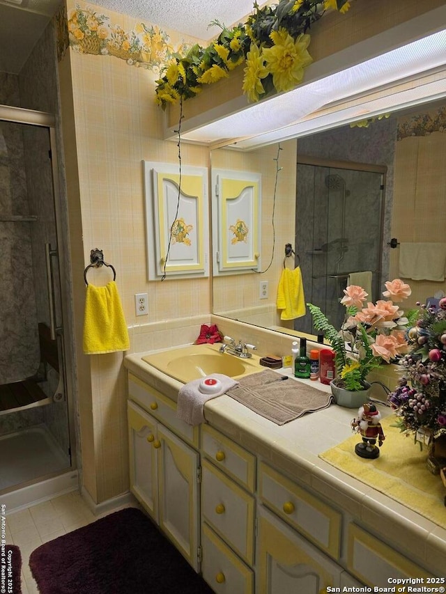 9840 Tower Vw, Helotes, TX 78023 - bathroom featuring wallpapered walls, vanity, tile patterned flooring, and a stall shower