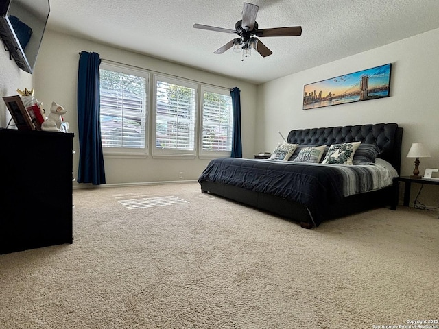 carpeted bedroom with a textured ceiling and ceiling fan